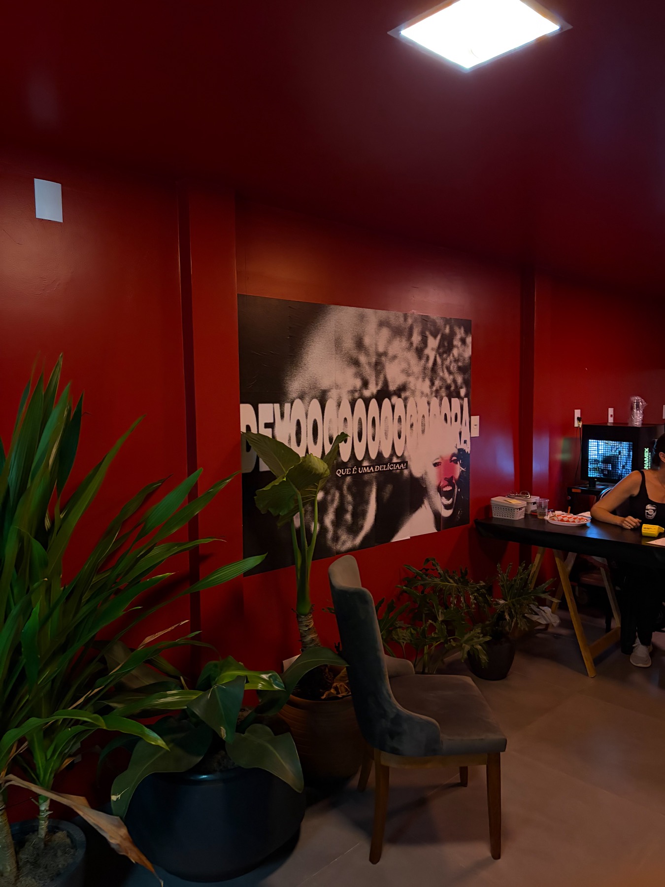 Bar da Vila Devora, parede vermelha com o pôster Devoooora