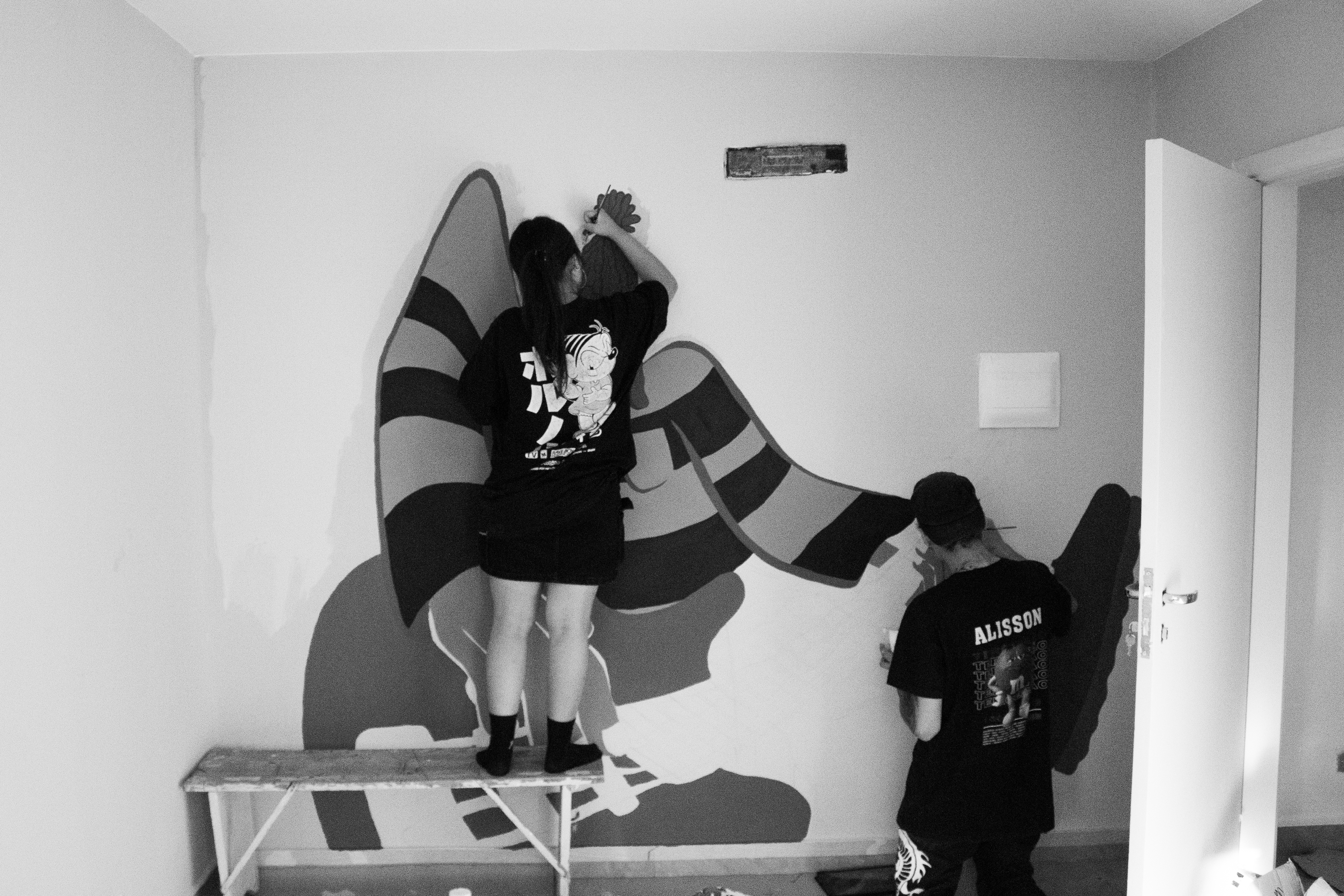 Artista pintando mural de grafite na Vila Devora